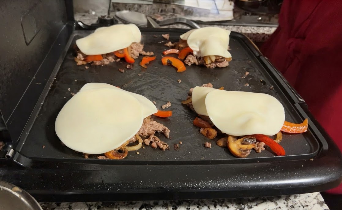 Cheesesteak piles with provolone on the griddle